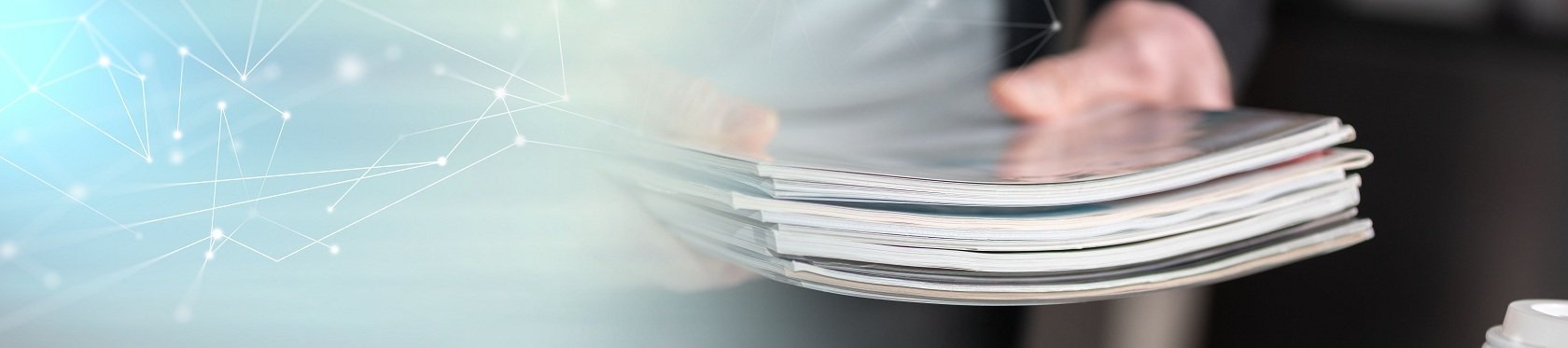 Mann hält einen Stapel Zeitschriften