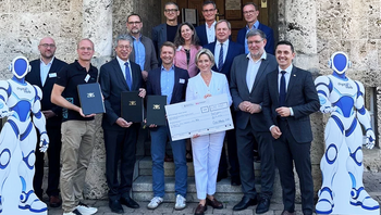 Gruppe von Menschen übergibt symbolischen Fördergutschein