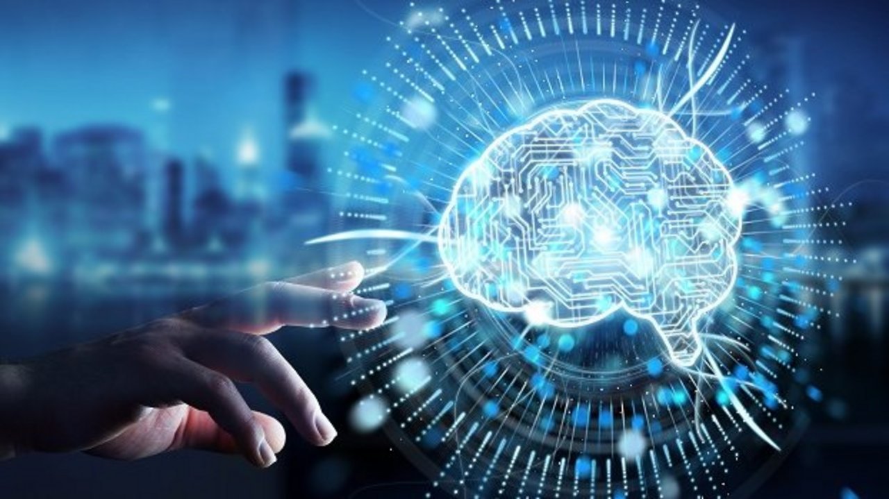 Digitale Illustration eines leuchtenden Gehirns mit Schaltkreismustern vor unscharfer Stadtsilhouette. Eine Hand greift nach der Darstellung, die von Lichtstrahlen und Datenlinien umgeben ist.