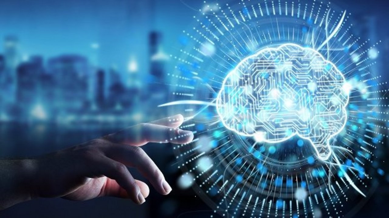 Digitale Illustration eines leuchtenden Gehirns mit Schaltkreismustern vor unscharfer Stadtsilhouette. Eine Hand greift nach der Darstellung, die von Lichtstrahlen und Datenlinien umgeben ist.