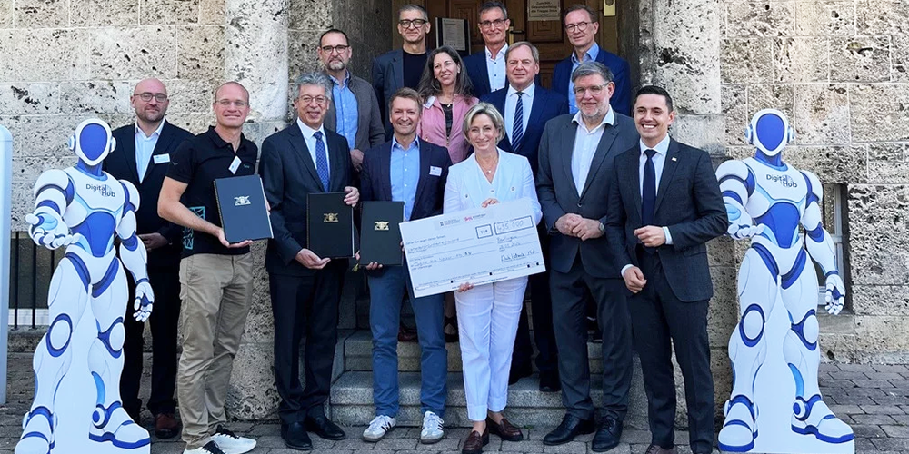 Gruppe von Menschen übergibt symbolischen Fördergutschein